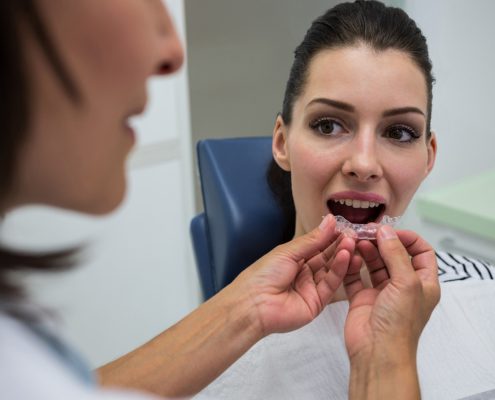 dentist-assisting-patient-wear-invisible-braces